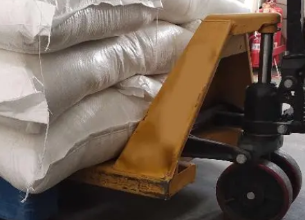 面粉厂生产车间工作人员用手动叉车搬运面粉